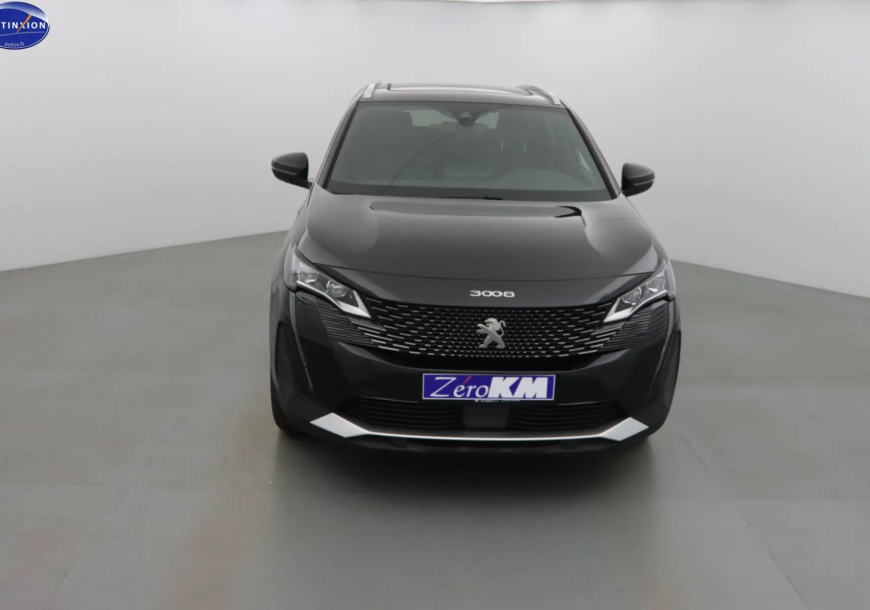 Vue frontale d'un Peugeot 3008 noir perle métal avec calandre distinctive et plaque "Zéro KM" visible.