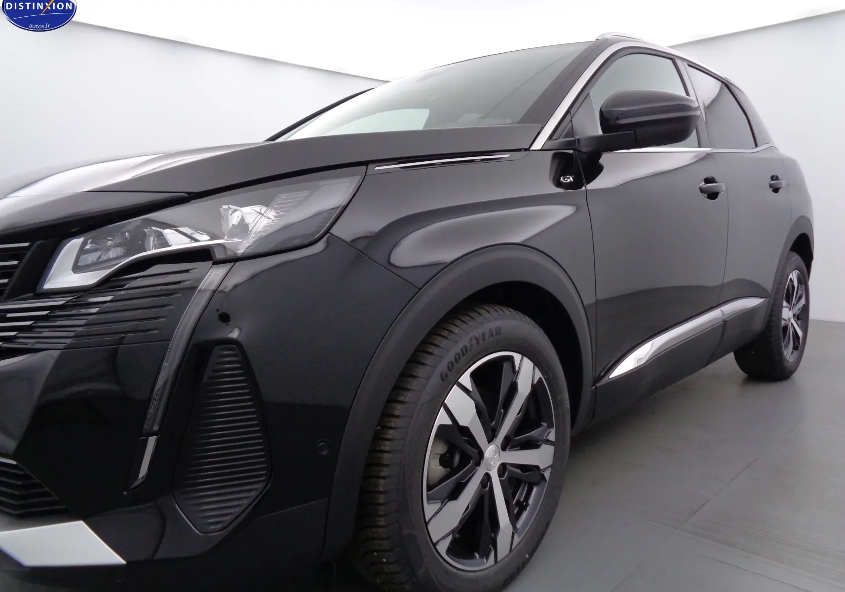 Peugeot 3008 noir perle métal en vue 3/4 avant droit, avec jantes alliage bicolores et badge GT visible sur l'aile.