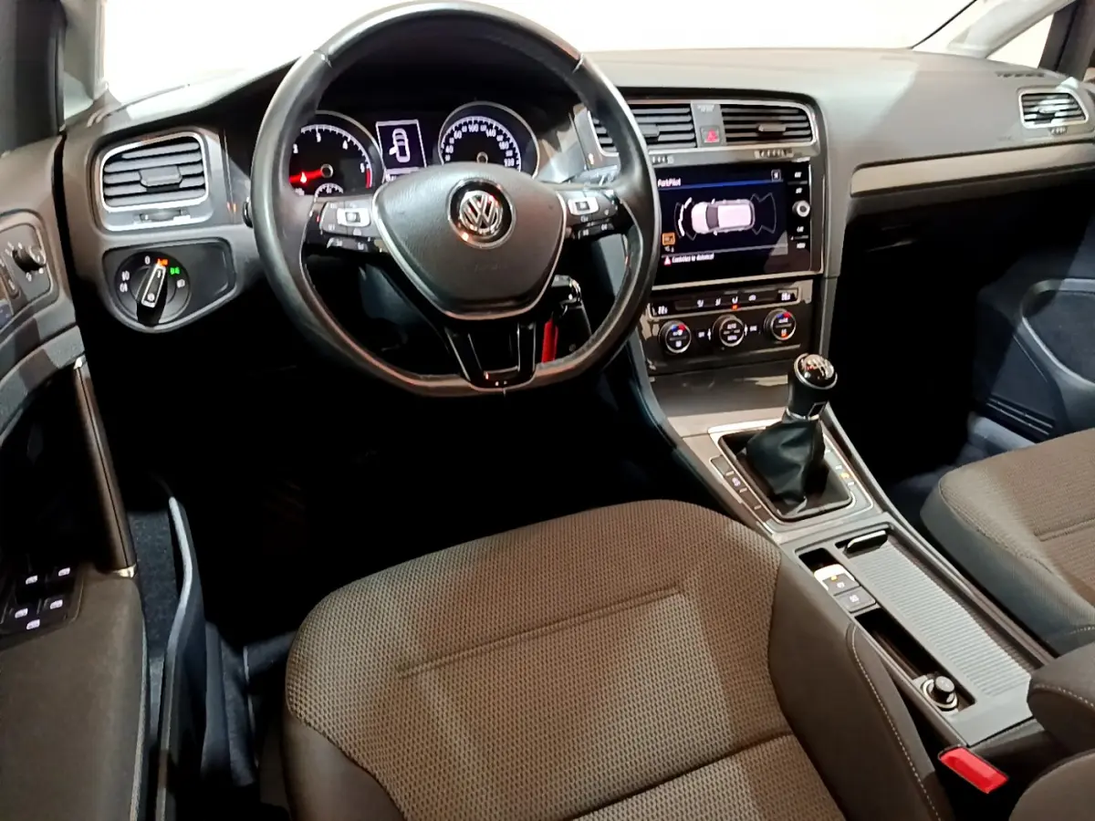 Vue intérieure avant de la Volkswagen Golf 1.6 TDI 2018, tableau de bord noir avec écran tactile et boîte manuelle.