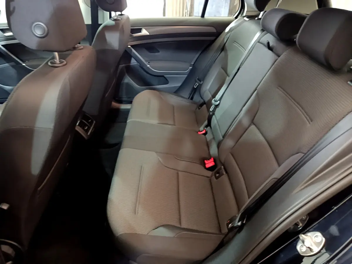 Vue intérieure côté droit des sièges arrière gris foncé d'une Volkswagen Golf noire de 2018, avec ceintures et appuie-têtes visibles.