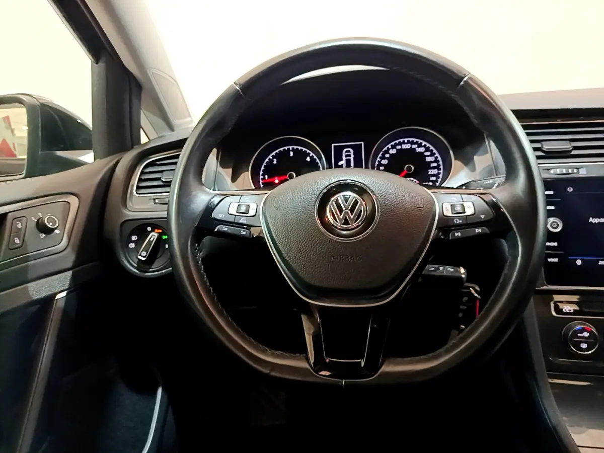 Vue intérieure centrée sur le volant cuir noir de la Volkswagen Golf 2018 avec tableau de bord et commandes visibles.