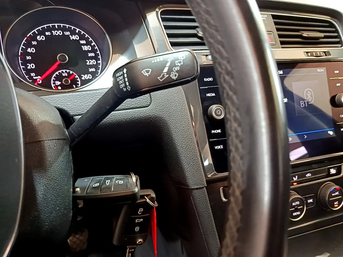 Vue intérieure rapprochée du tableau de bord et volant cuir noir d’une Volkswagen Golf 2018 avec écran tactile et commandes au volant.