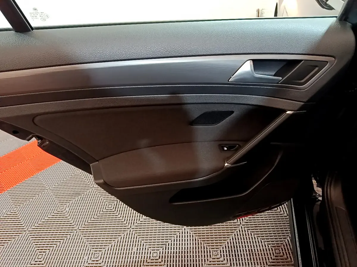 Vue intérieure côté droit de la porte avant noire de la Volkswagen Golf 2018 avec poignée argentée et panneau en bois.