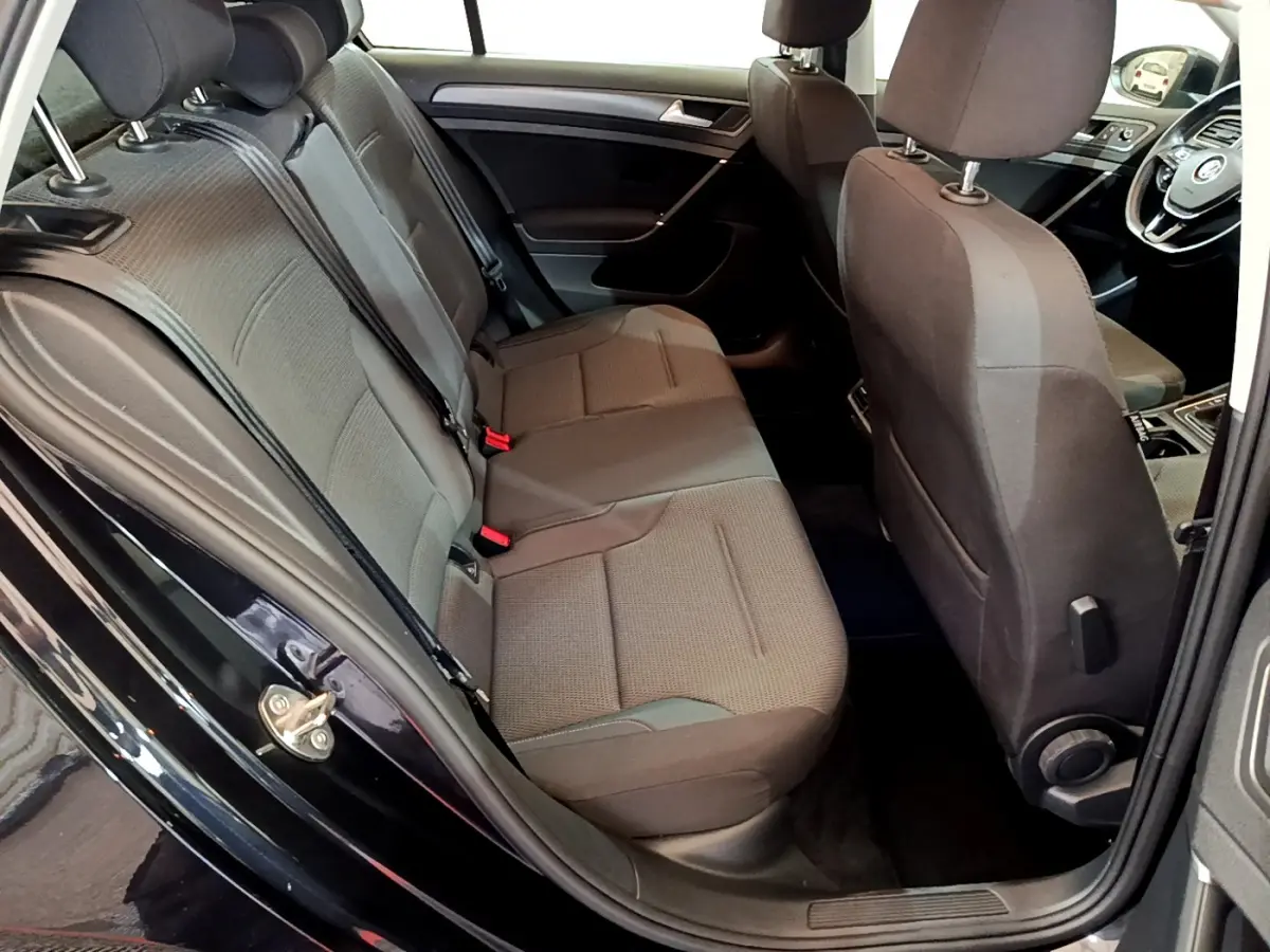 Vue intérieure côté gauche montrant la banquette arrière noire et les sièges avant d'une Volkswagen Golf 2018.