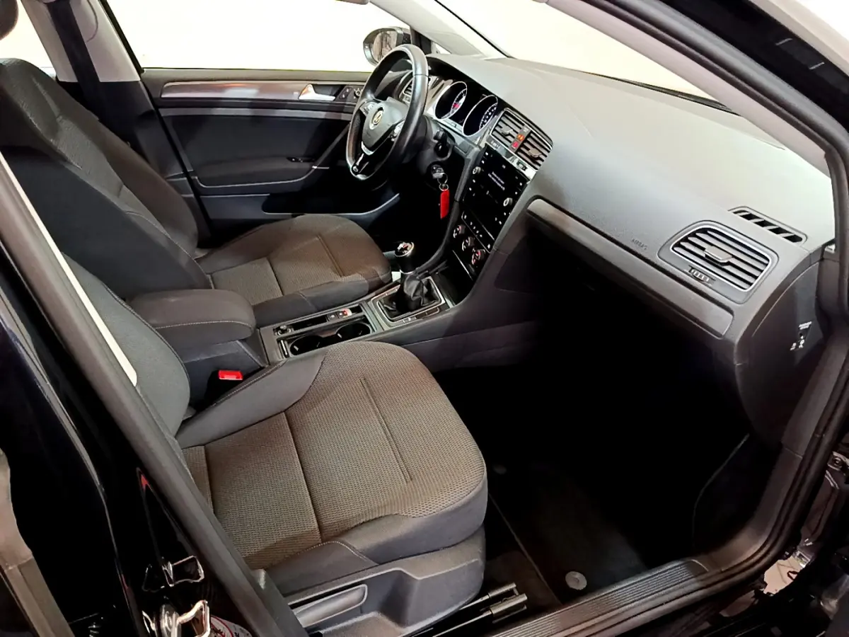 Intérieur noir de la Volkswagen Golf 2018, vue côté conducteur, avec tableau de bord et sièges tissu visibles.