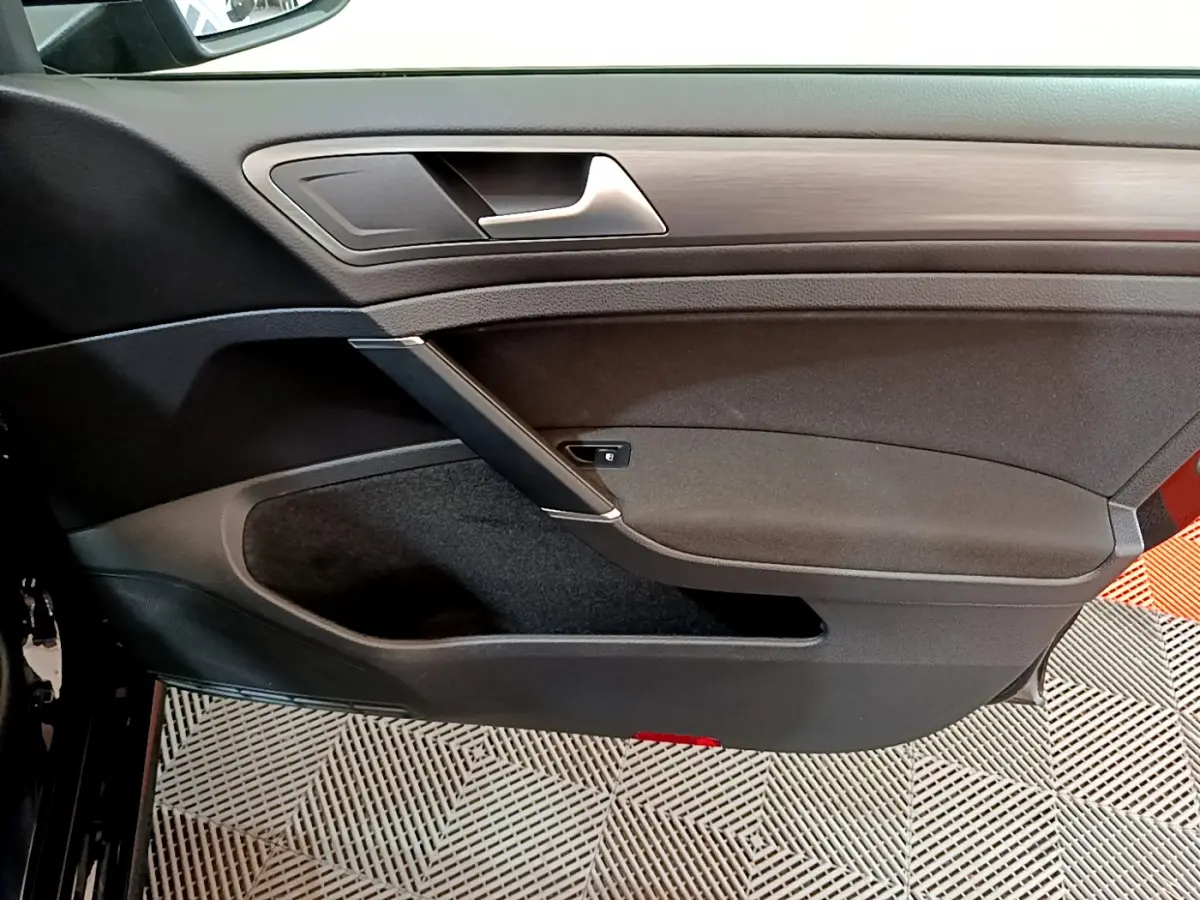 Vue intérieure côté gauche de la porte avant noire d’une Volkswagen Golf 2018 avec insert décoratif bois.