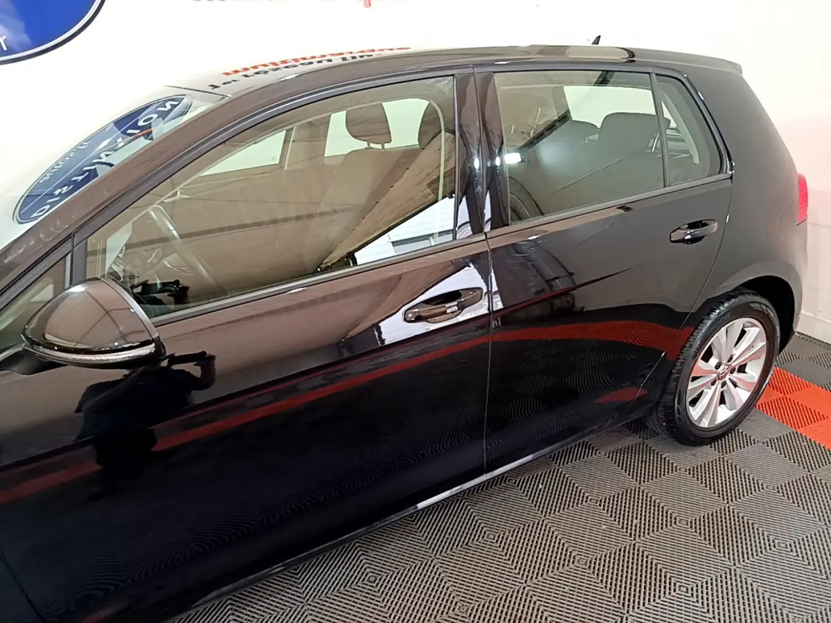 Vue latérale côté gauche d'une Volkswagen Golf noire 2018, mettant en valeur les vitres teintées et les jantes alliage.