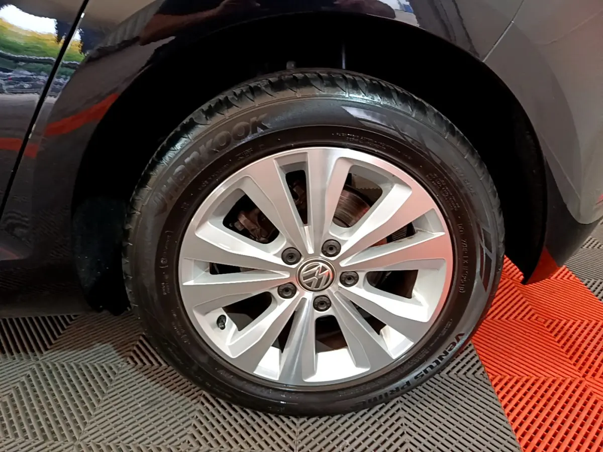 Gros plan sur la roue avant droite d'une Volkswagen Golf noire avec jante alliage argentée et pneu Hankook.