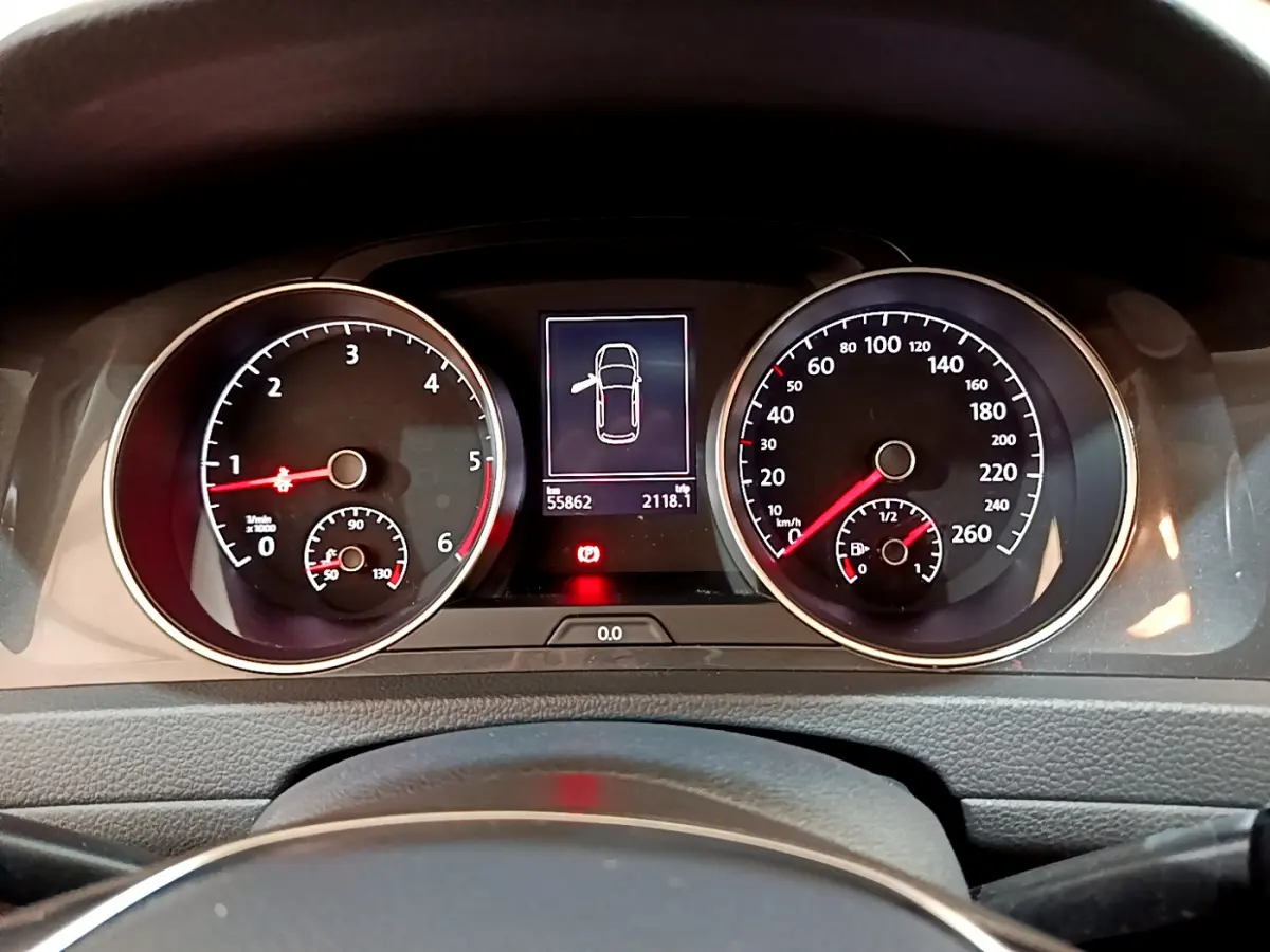 Vue rapprochée du tableau de bord de la Volkswagen Golf noire, affichant compte-tours, vitesse et écran multifonctions.