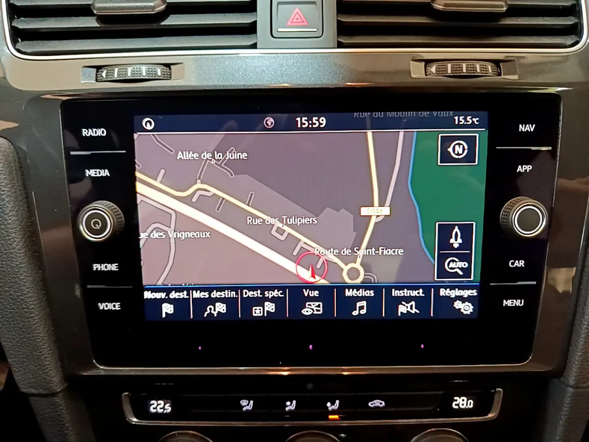 Vue rapprochée de l’écran tactile central de navigation d’une Volkswagen Golf noire, affichant une carte routière.