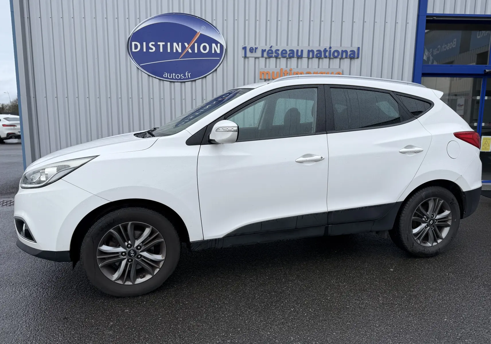 Vue de profil côté gauche d'un Hyundai ix35 blanc de 2014 avec jantes alliage et rétroviseurs blancs.