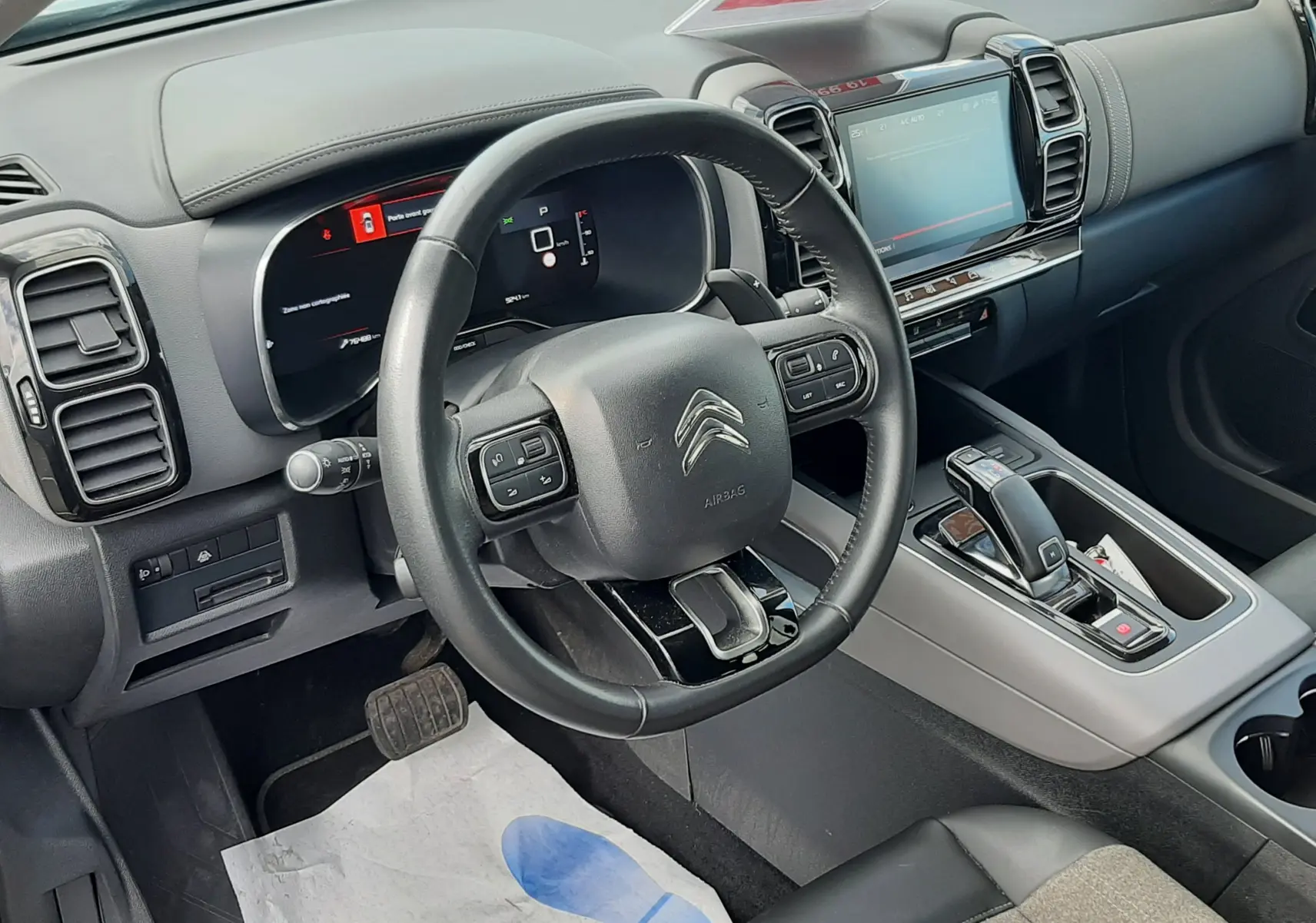 Vue intérieure côté conducteur du Citroën C5 Aircross noir, montrant le volant multifonction et la console centrale moderne.
