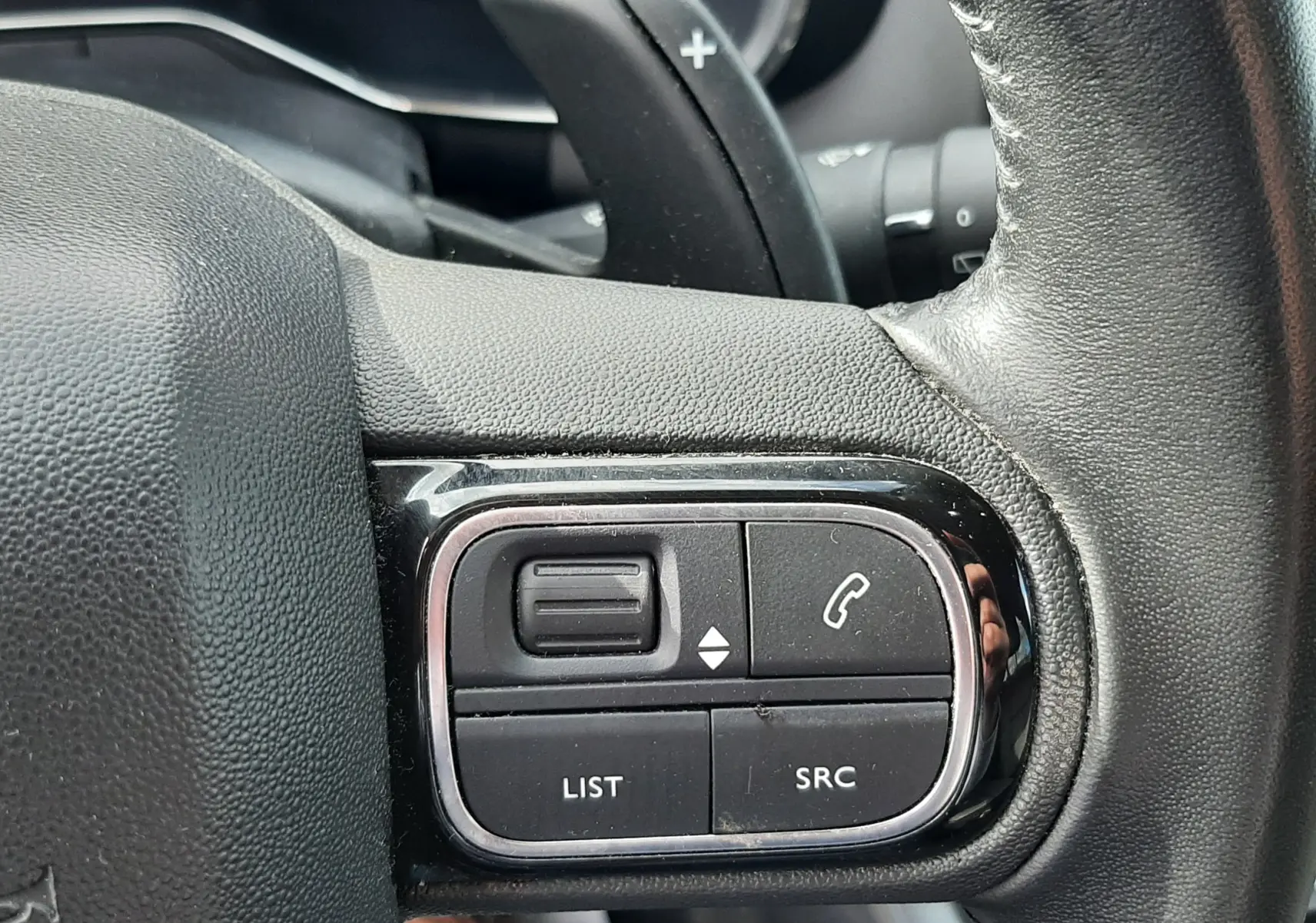 Gros plan sur les commandes gauche du volant en cuir noir du Citroën C5 Aircross 2020, boutons de gestion audio et appel.