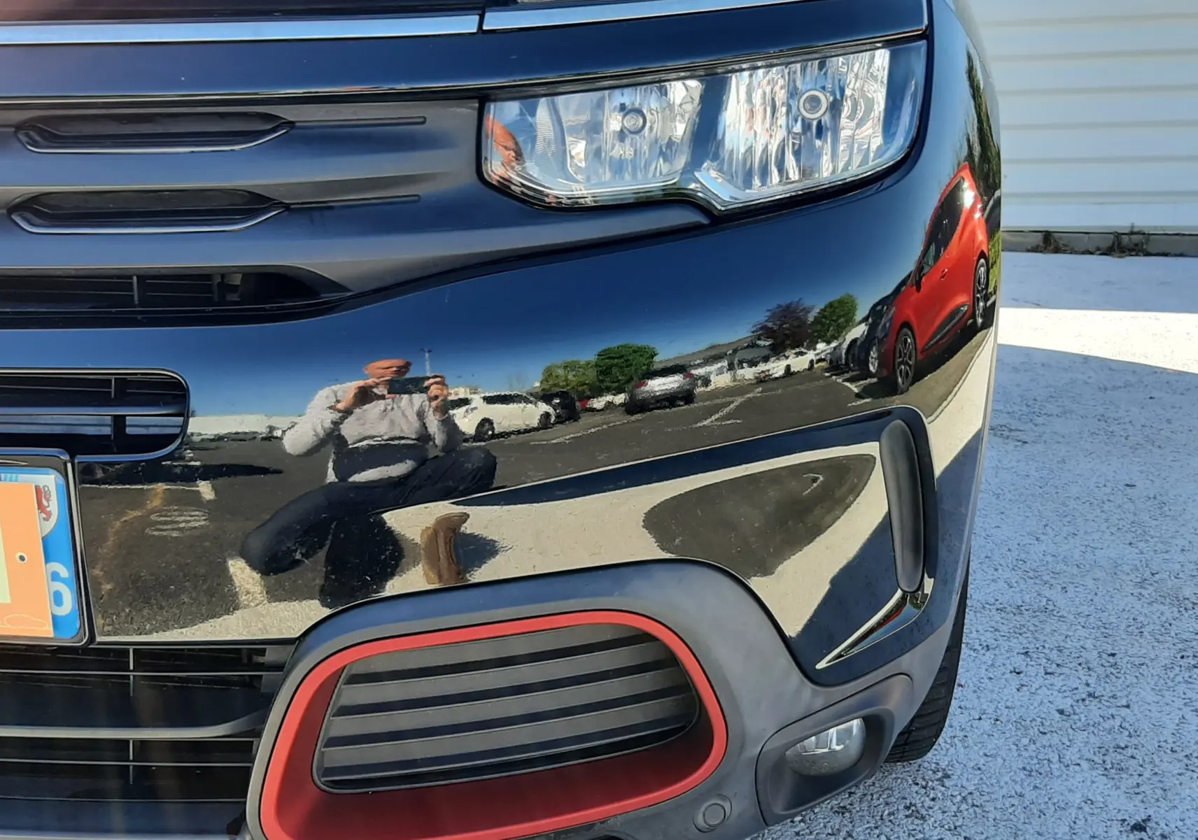 Gros plan sur l’avant droit noir brillant du Citroën C5 Aircross avec encadrement rouge autour de la prise d’air.