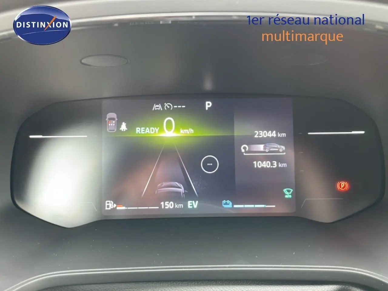 Tableau de bord numérique de la Renault Symbioz blanc nacré, affichant la vitesse et l'autonomie en mode hybride.