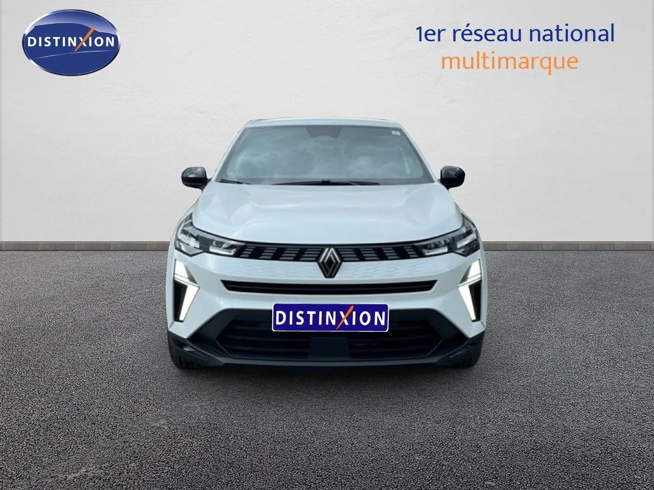 Vue de face du Renault Symbioz blanc nacré avec calandre noire et feux LED verticaux allumés.
