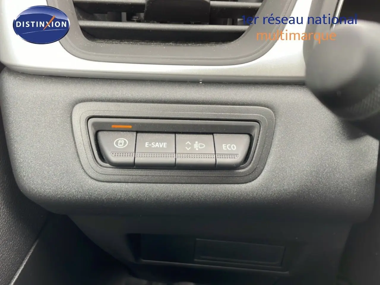Gros plan sur les boutons de contrôle E-SAVE et ECO du tableau de bord d’une Renault Symbioz blanche nacrée.