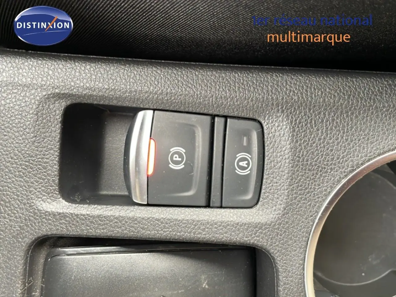 Vue intérieure en gros plan sur les commandes de frein de stationnement et d'arrêt automatique du Renault Symbioz blanc nacré.