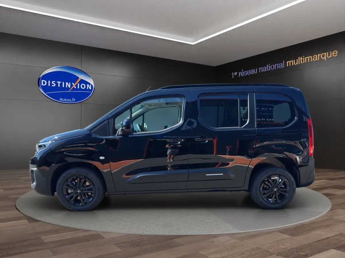 Profil latéral droit d'un Citroën Berlingo noir 2026 avec jantes noires, présenté en showroom intérieur.