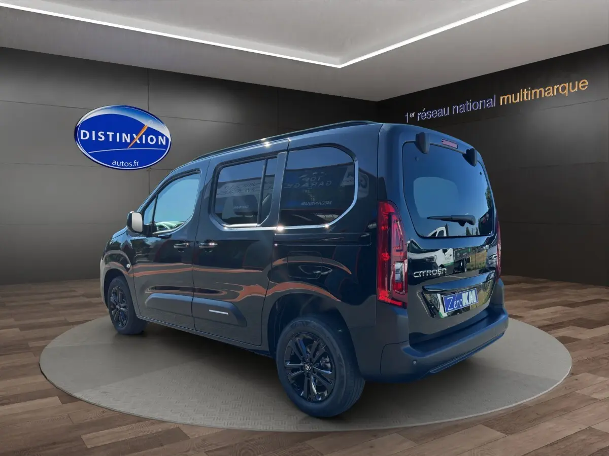 Vue 3/4 arrière droite du Citroën Berlingo noir 2026 avec vitres teintées et jantes foncées en showroom.