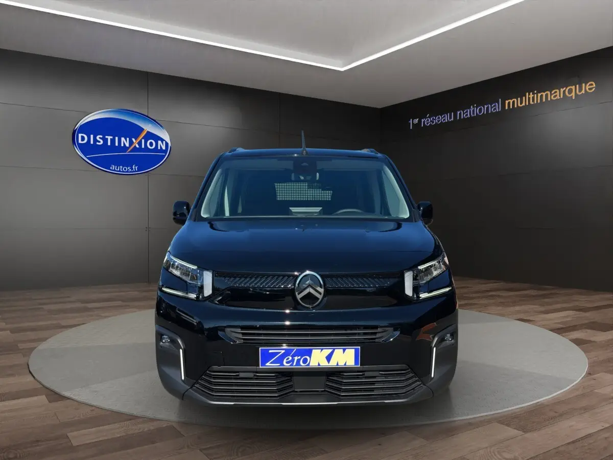 Vue de face du Citroën Berlingo noir 2026 dans un showroom avec logo Distinxion en arrière-plan.