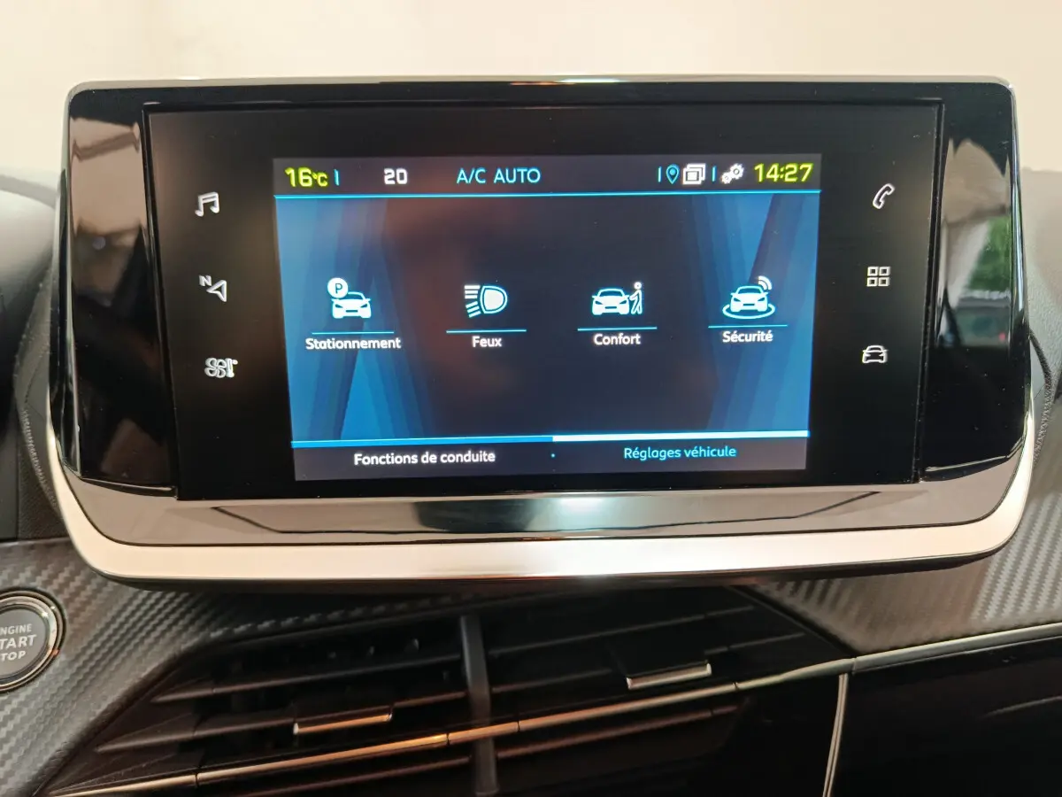 Écran tactile central du tableau de bord de la Peugeot 208 électrique, affichant les réglages de conduite et sécurité.