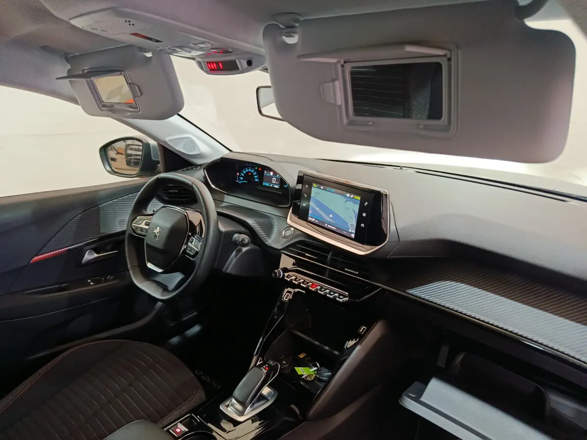 Intérieur de la Peugeot 208 électrique gris clair, vue côté conducteur sur tableau de bord et écran tactile central.