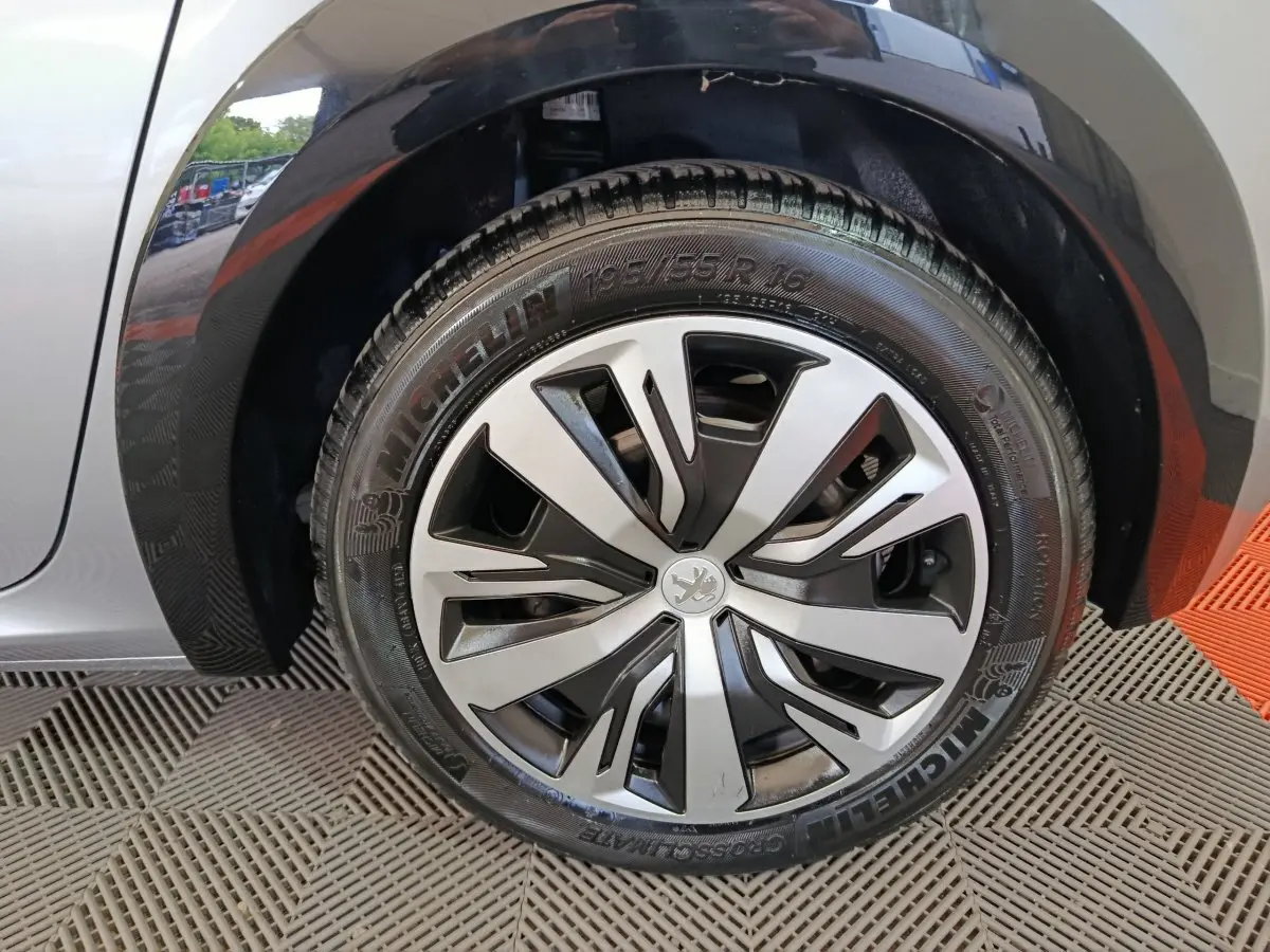 Gros plan sur la roue avant gauche gris clair de la Peugeot 208 Electrique Active Business avec jante stylisée.