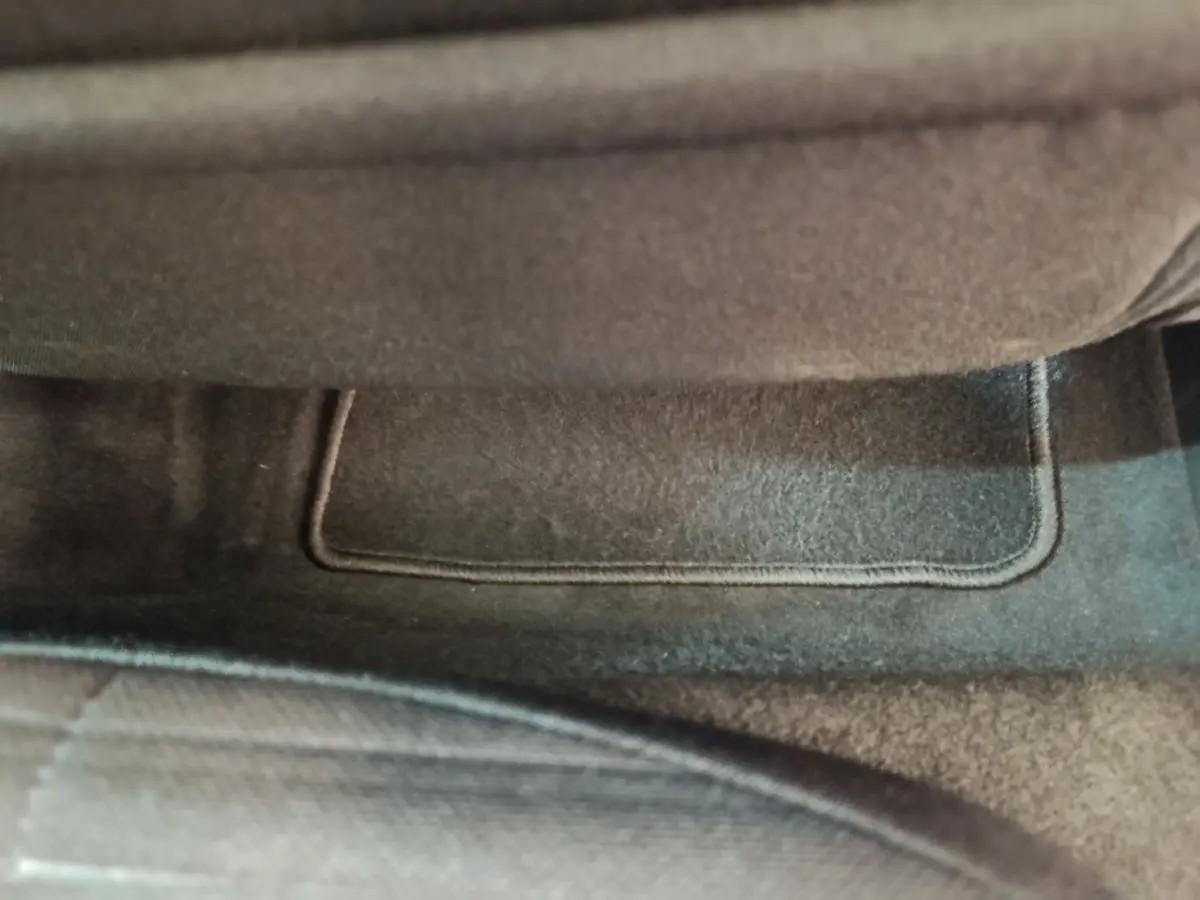 Gros plan sur le tapis de sol gris foncé sous le siège avant d'une Peugeot 208 électrique Active Business 2020.