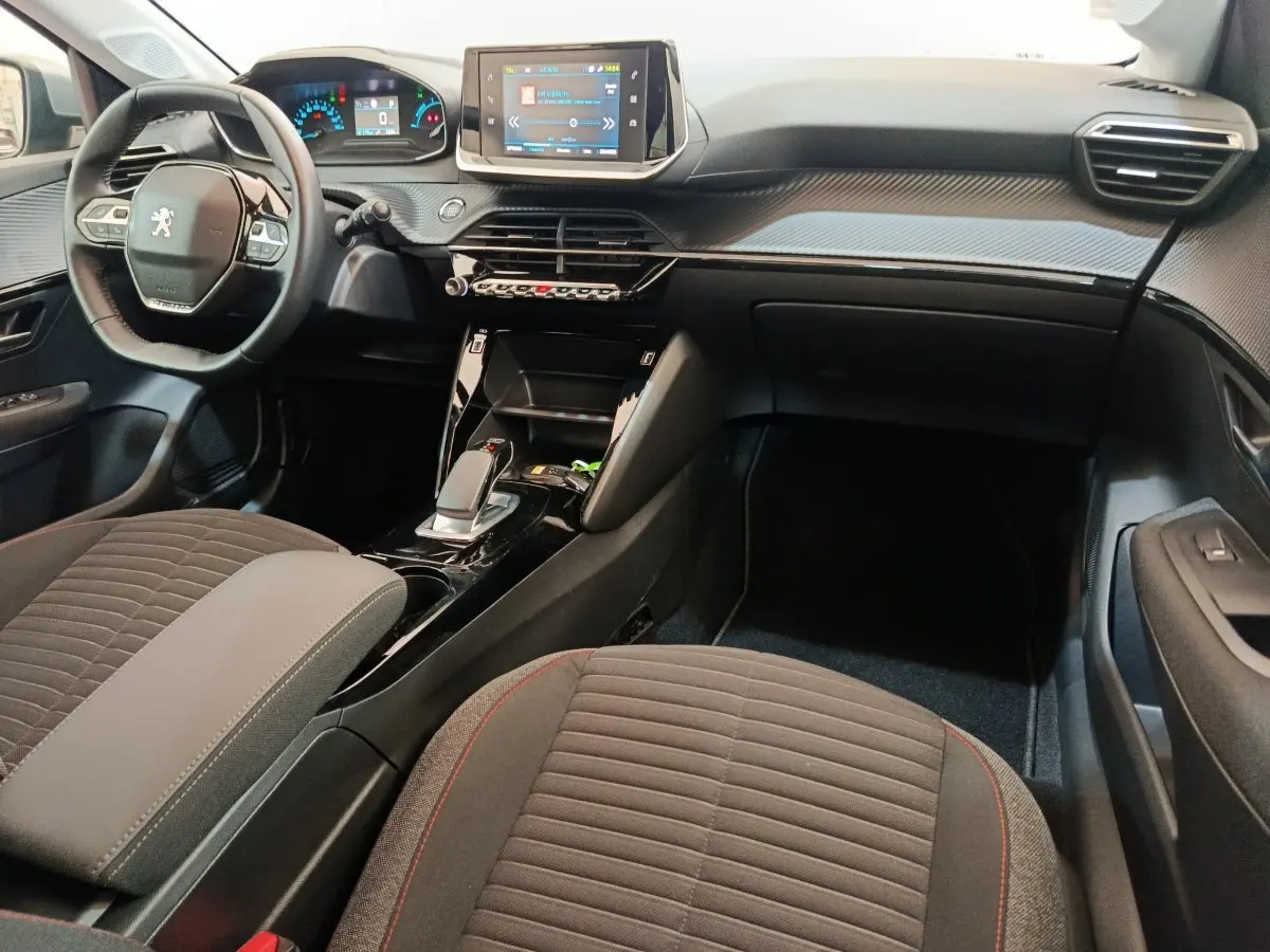 Intérieur de la Peugeot 208 Electrique Active Business 2020 vu côté passager, tableau de bord noir avec écran tactile central.