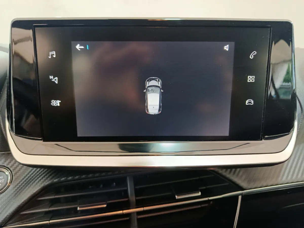 Écran tactile central de la Peugeot 208 électrique Active Business montrant la vue aérienne du véhicule en gris clair.