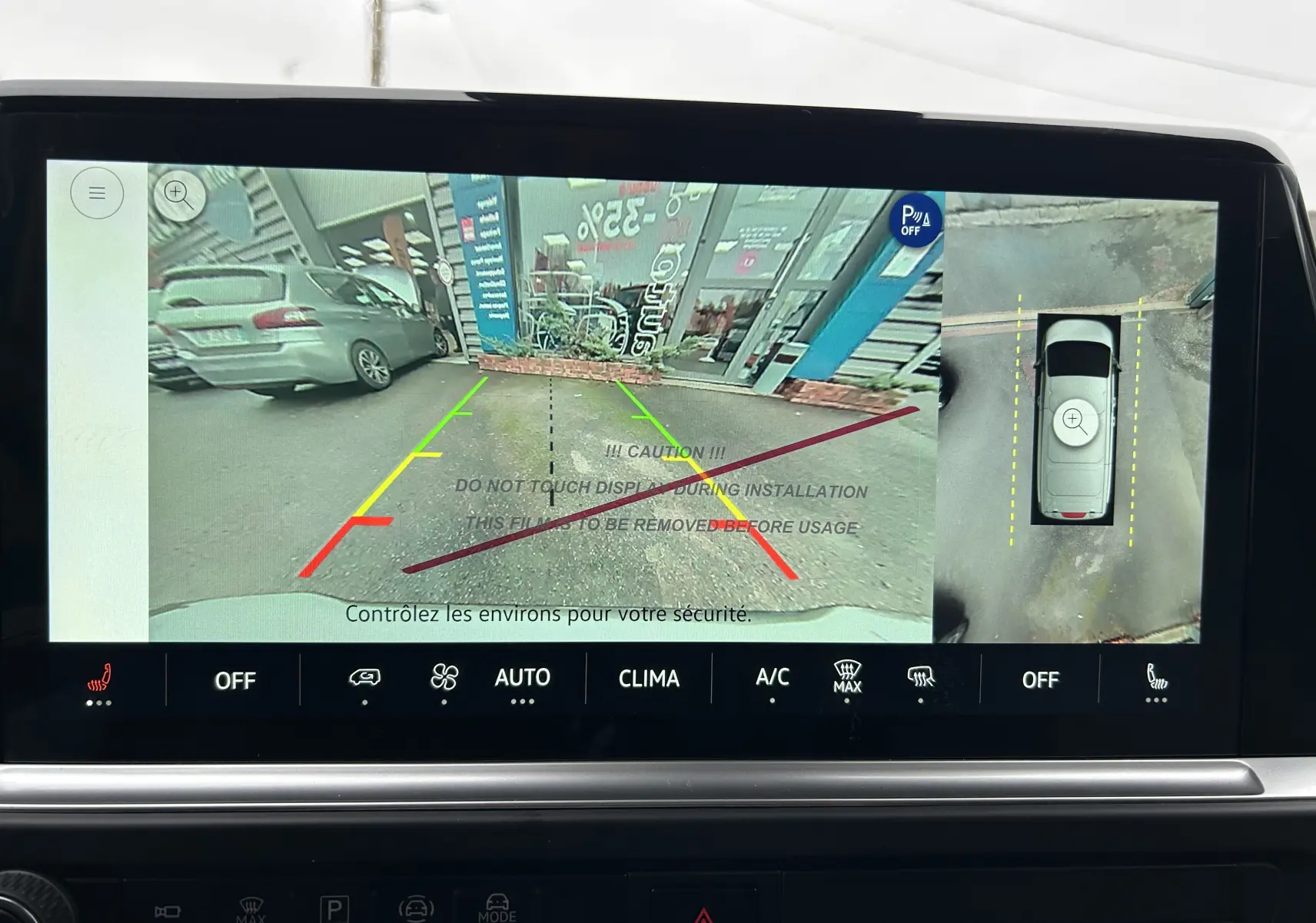 Affichage caméra de recul et vue aérienne du Volkswagen Transporter T7 Business gris Graphite Dust en stationnement.