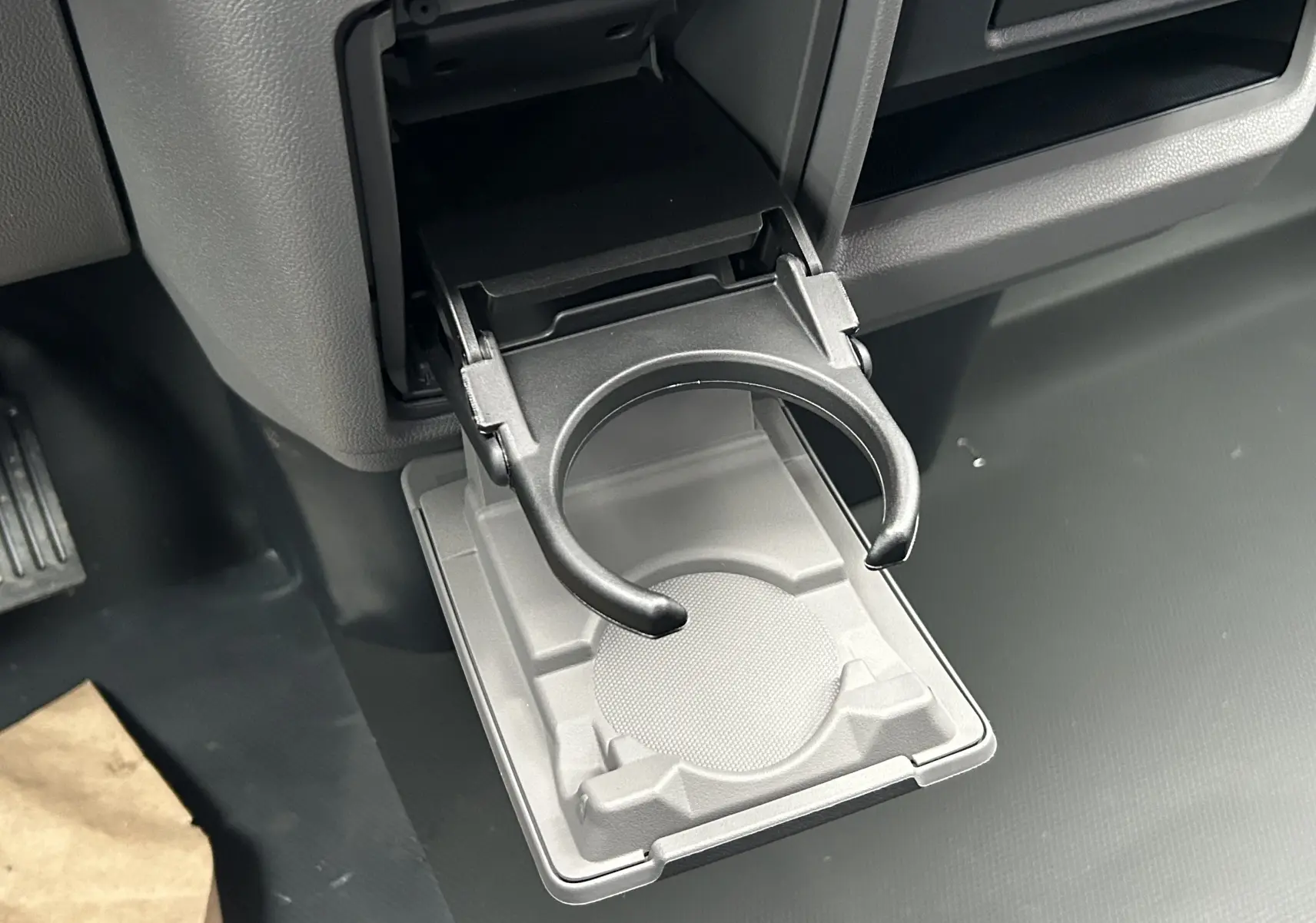 Porte-gobelet déployé dans l’habitacle du Volkswagen Transporter T7 ProCab, intérieur gris foncé.