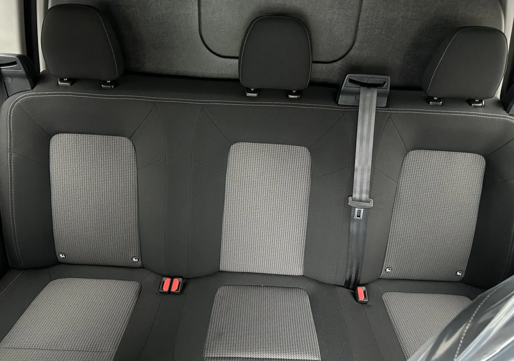 Vue rapprochée de la banquette arrière en tissu gris et noir du Volkswagen Transporter T7 ProCab 2026.