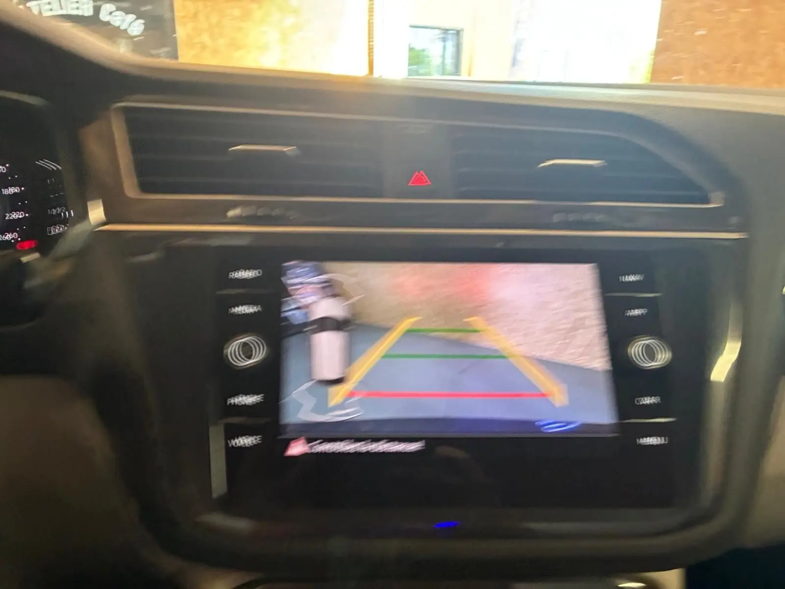 Écran tactile central du Volkswagen Tiguan 2023 montrant la caméra de recul avec lignes de guidage en intérieur noir.