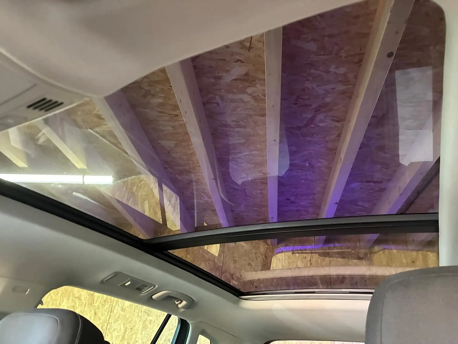 Vue intérieure du toit ouvrant panoramique du Volkswagen Tiguan 2023, avec ciel visible à travers le verre teinté.