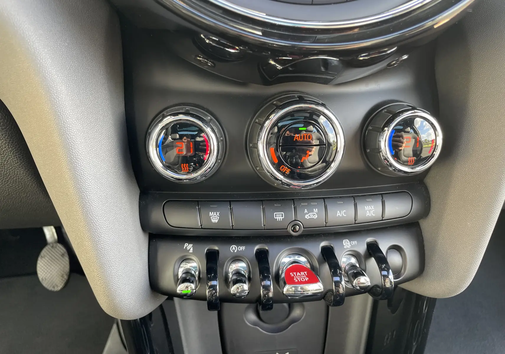 Gros plan sur la console centrale de la MINI F56 Cooper S 2015, montrant les commandes de climatisation et le bouton start/stop rouge.