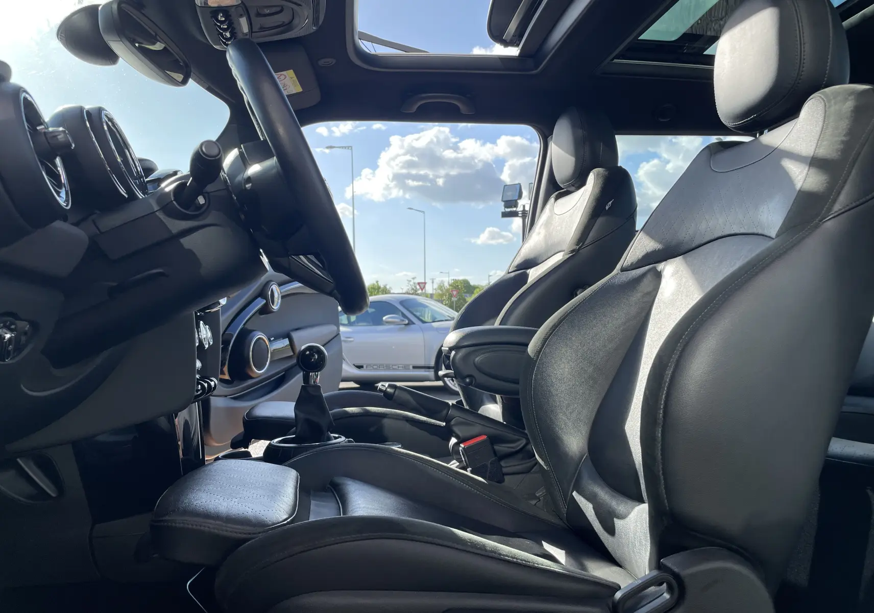 Intérieur de la MINI F56 Cooper S 2015 vu côté conducteur, sièges en cuir noir et toit ouvrant panoramique.