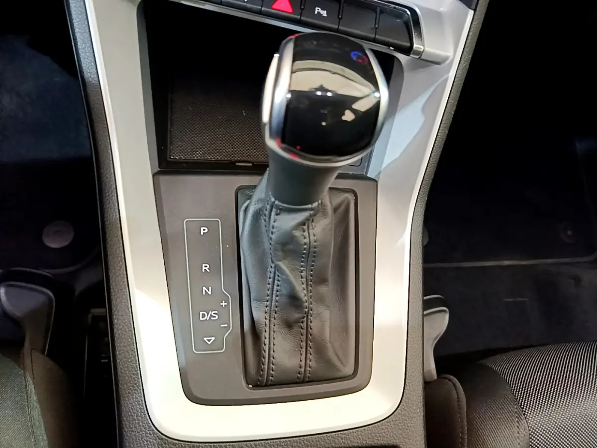 Vue rapprochée de la commande de boîte automatique noire et argentée dans l’Audi Q3 35 TDI 2021, intérieur sombre.