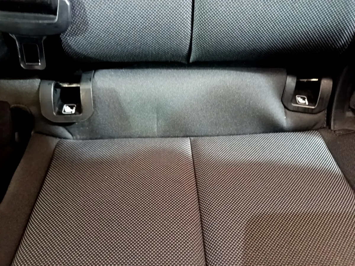 Détail de la banquette arrière noire de l'Audi Q3 35 TDI 150 S tronic Business Line, vue rapprochée du tissu et des fixations Isofix.