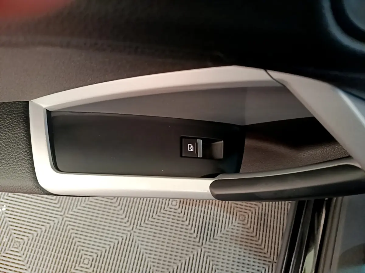 Gros plan sur la poignée intérieure de porte côté conducteur de l’Audi Q3 noir avec bouton de verrouillage centralisé.