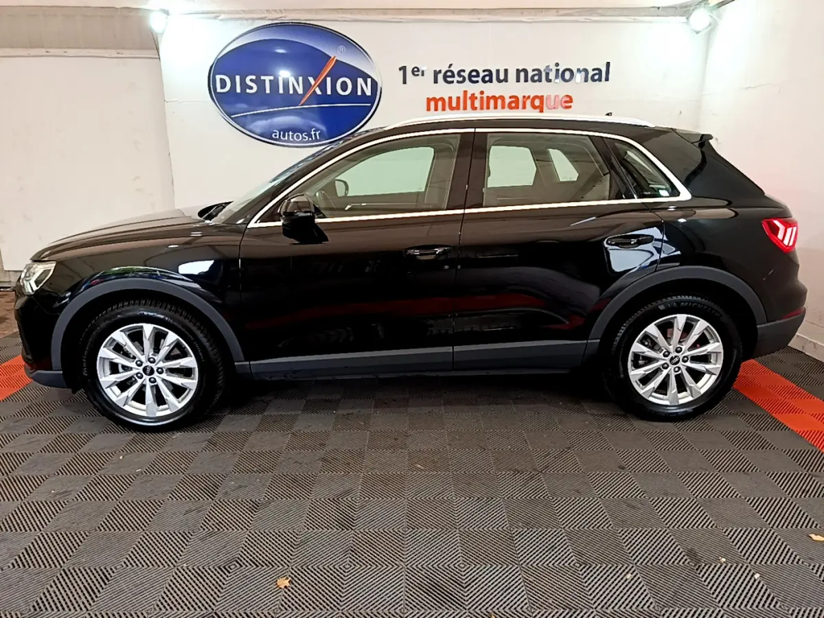Audi Q3 35 TDI 150 S tronic Business Line noir, vue de profil côté gauche en intérieur showroom.