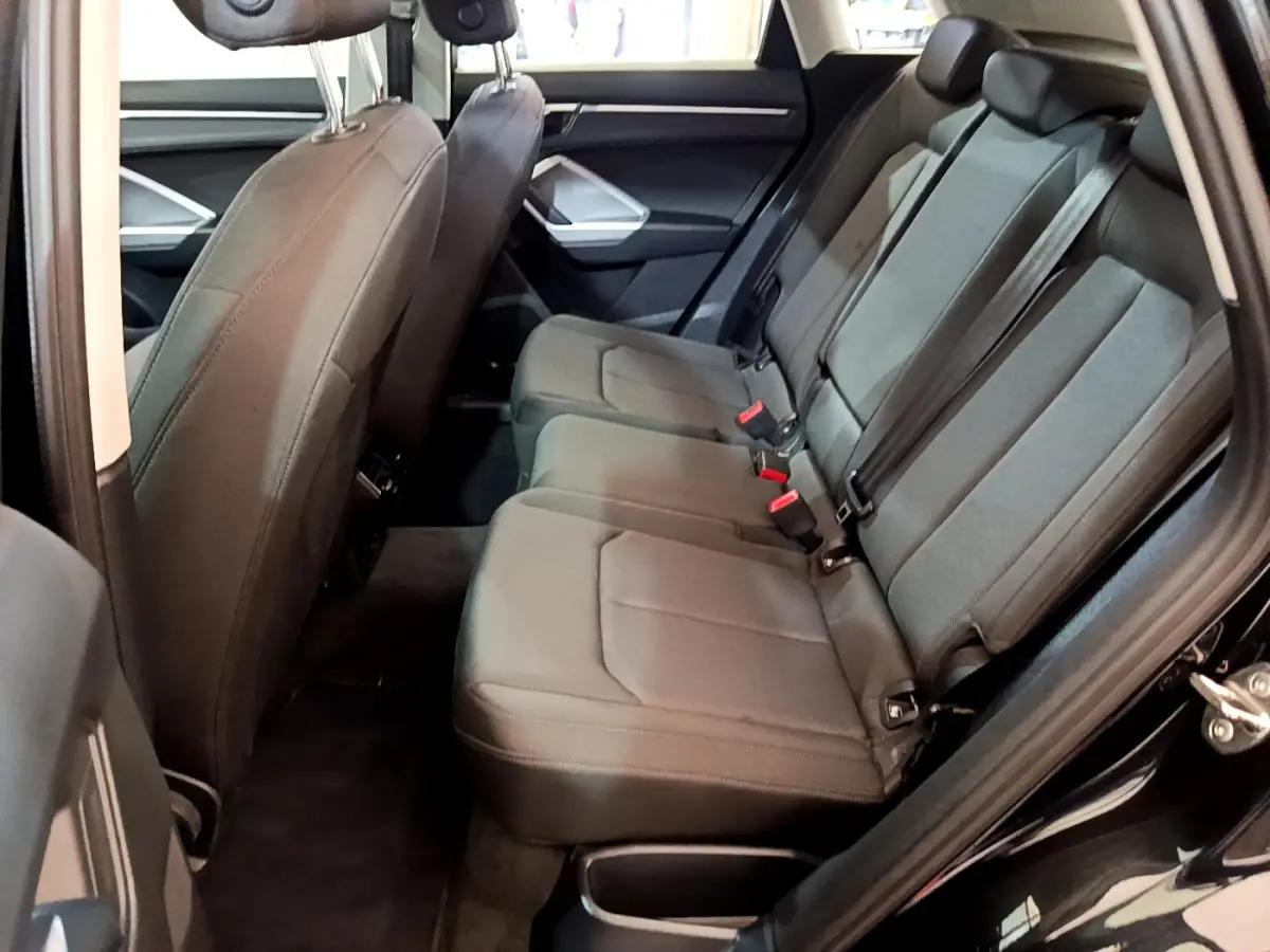 Vue intérieure côté droit sur la banquette arrière grise de l'Audi Q3 35 TDI Business Line noire de 2021.