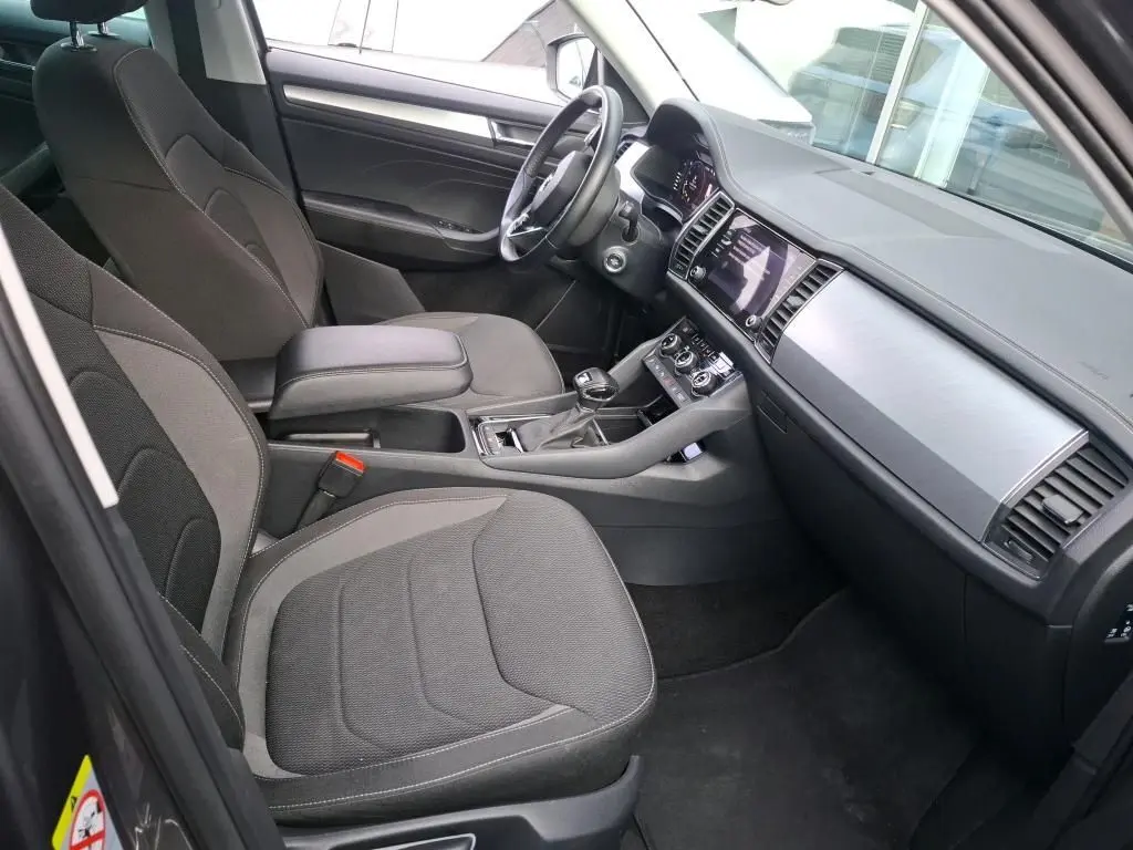 Vue 3/4 arrière droite d’un Skoda Kodiaq gris métallisé avec jantes alu 17 pouces dans un garage.