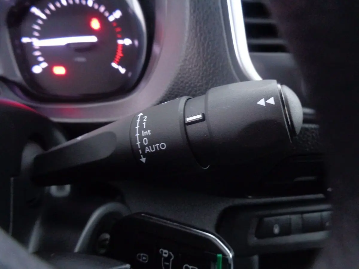 Gros plan sur la commande d’essuie-glace du Peugeot Expert Fourgon noir métal, tableau de bord en arrière-plan flou.