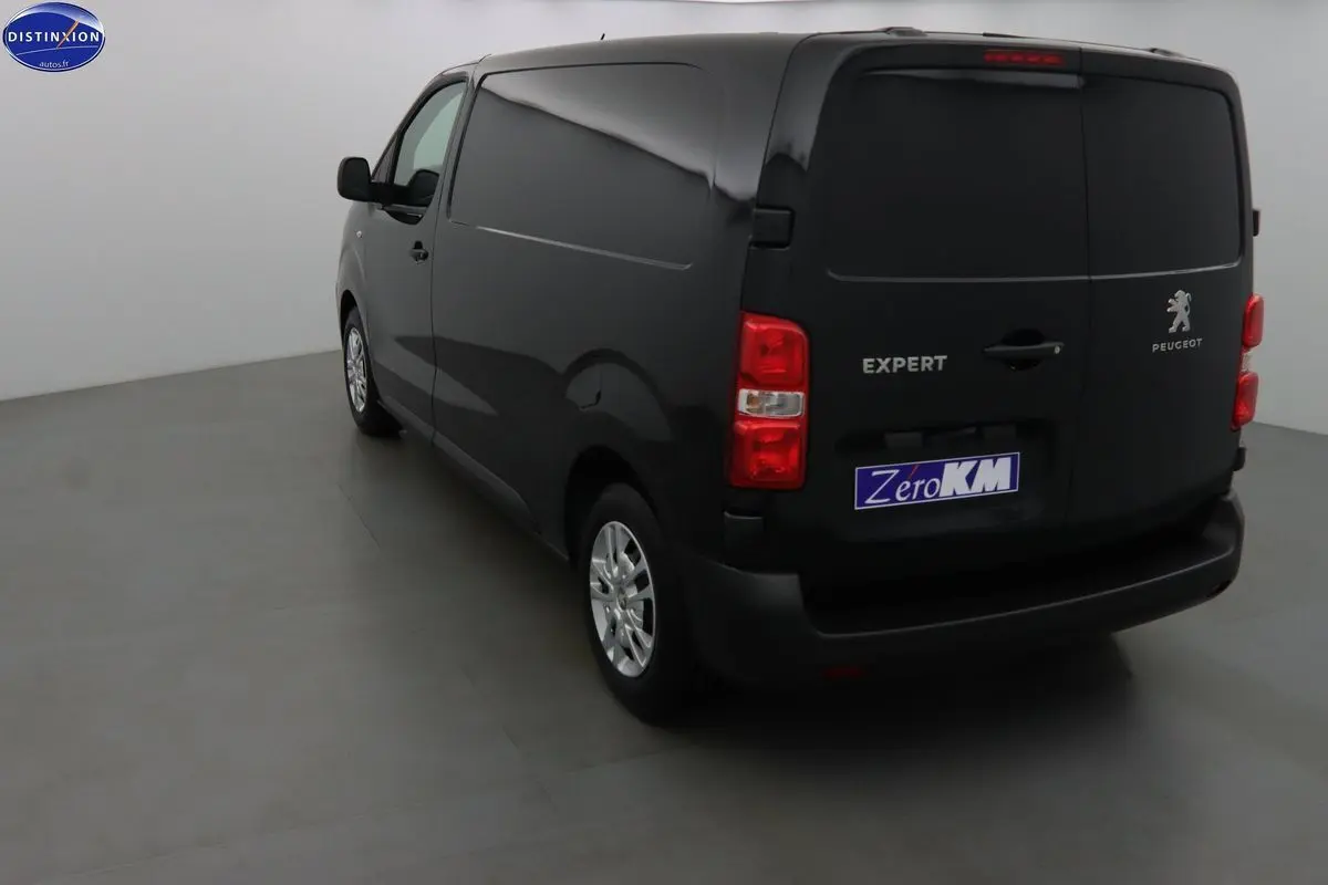 Vue 3/4 arrière droite du Peugeot Expert Fourgon noir métal 2022 avec logo et feux rouges visibles.