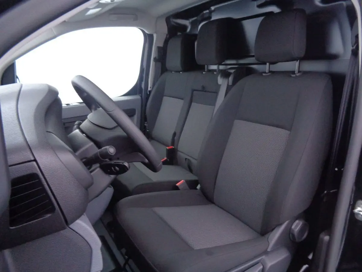 Vue intérieure côté conducteur du Peugeot Expert Fourgon 2022, sièges tissu gris et noir, volant visible.