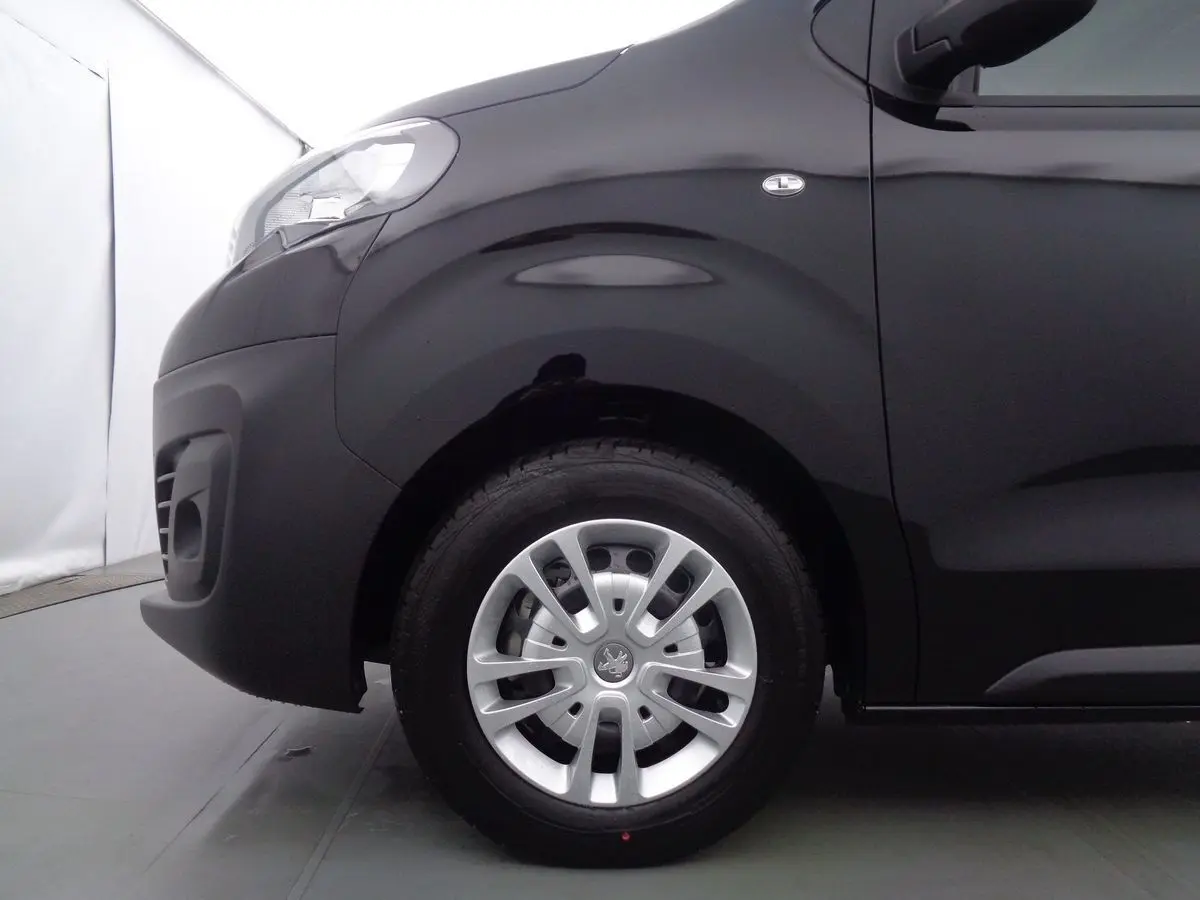 Vue latérale côté avant gauche du Peugeot Expert Fourgon noir métal, mettant en valeur la roue et l'aile avant.
