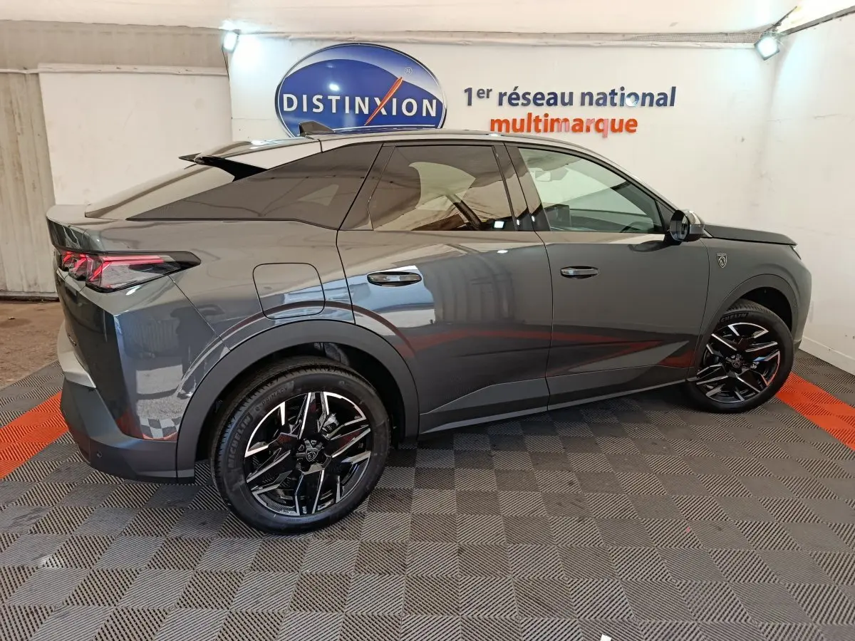 Peugeot 3008 gris foncé vue de profil côté droit, avec jantes noires et toit panoramique teinté.