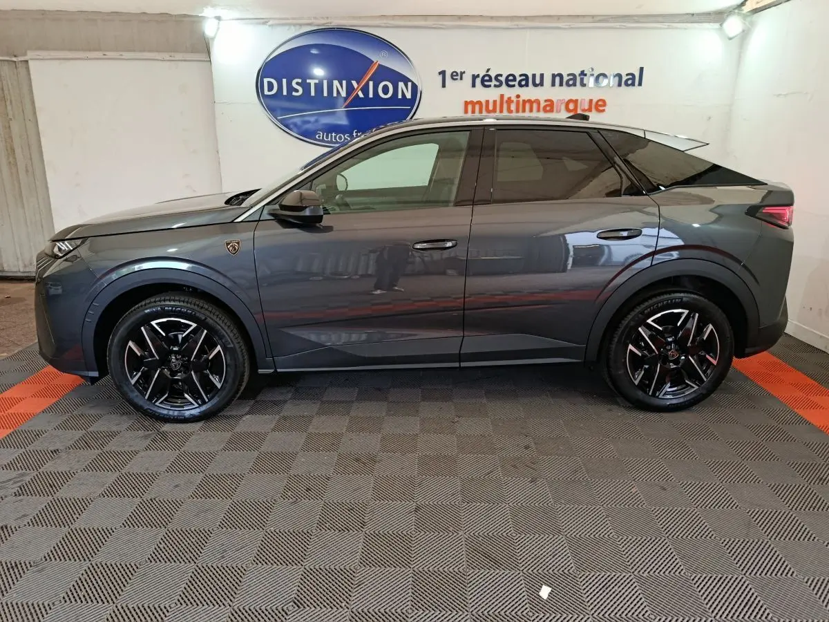 Profil côté gauche du Peugeot 3008 gris foncé 1.2 HYBRID 145 GT avec jantes noires et toit noir contrasté.